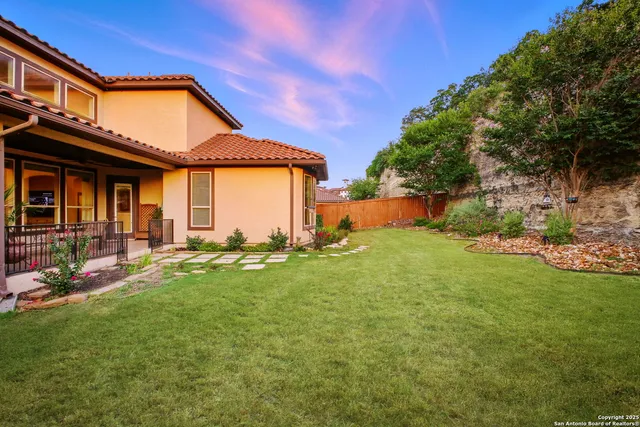 a front view of a house with a garden and lake view