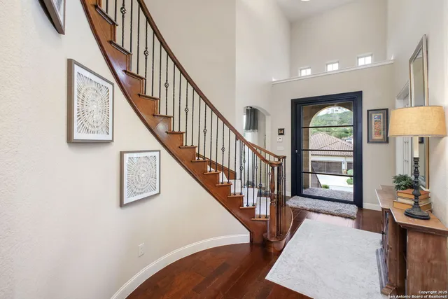 a view of a hallway with wooden floor windows and a chandelier