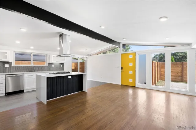 a large kitchen with stainless steel appliances granite countertop a large counter top and a wooden floors