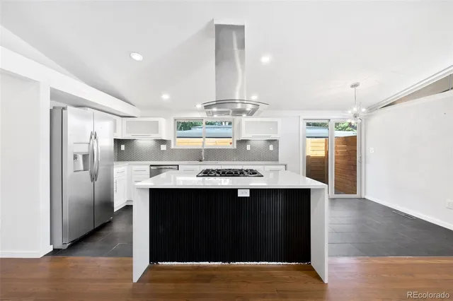 a view of kitchen with stainless steel appliances kitchen island sink refrigerator and wooden floor