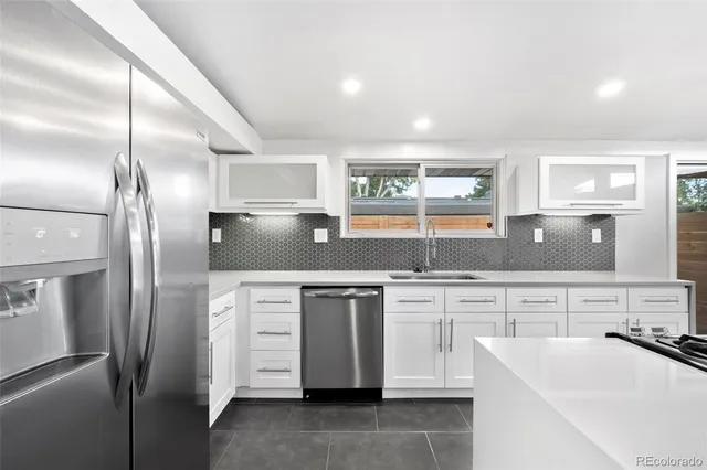 a kitchen with stainless steel appliances a refrigerator sink and stove