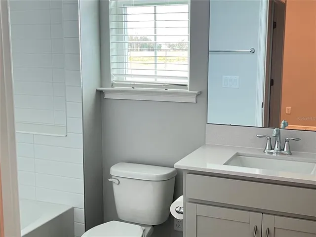 a bathroom with a toilet a sink and a window