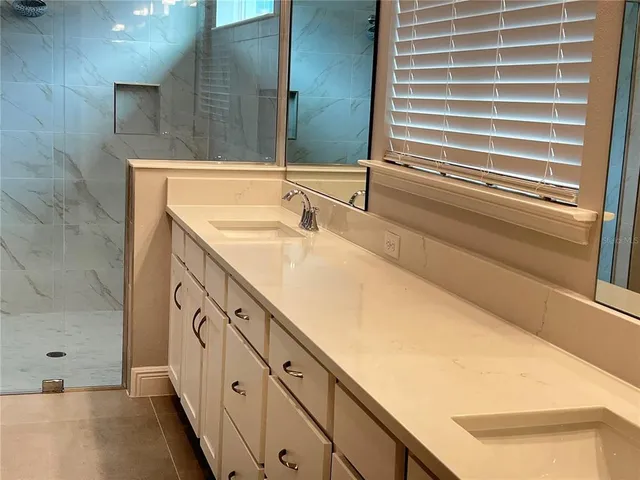 a bathroom with a granite countertop sink and a bathtub