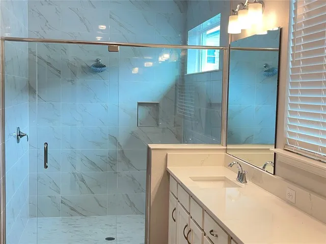 a bathroom with a granite countertop sink a shower and a mirror