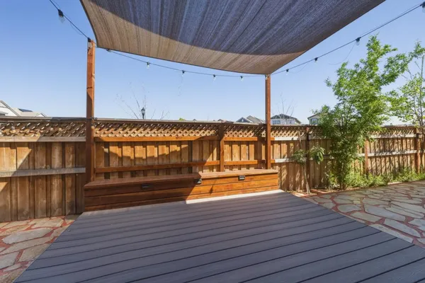 a view of a patio with table and chairs with wooden floor and fence