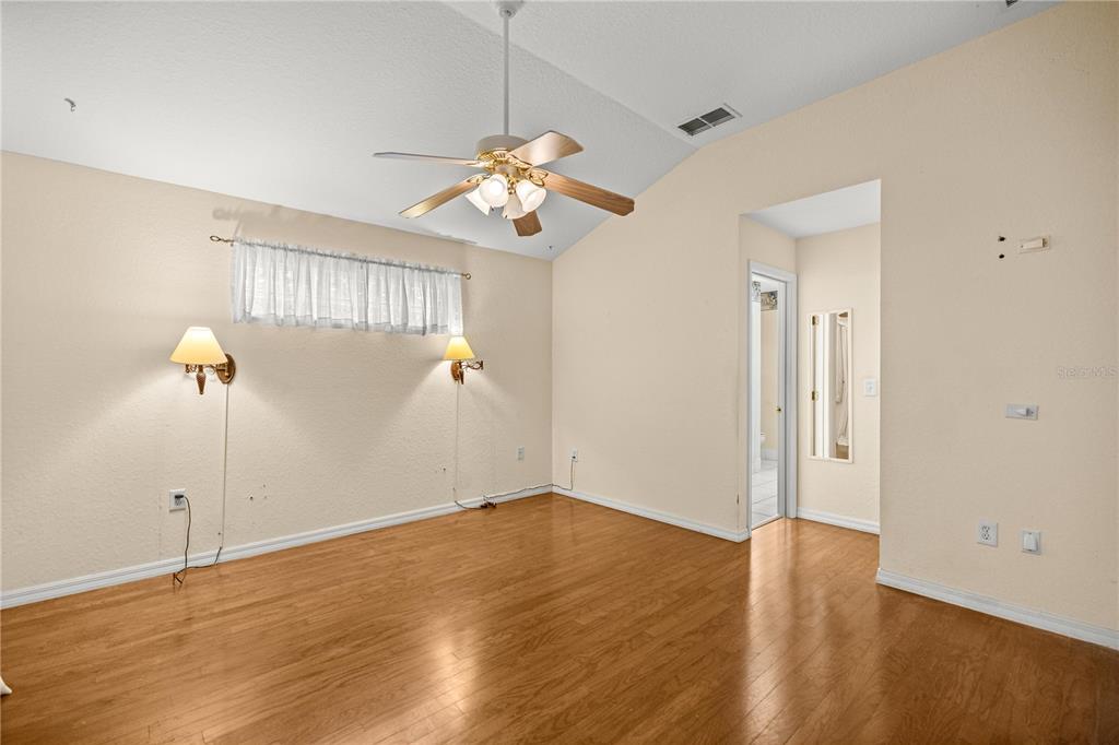 10891 Southwest 69th Circle Ocala, FL 34476 - Photo 14 of 28 a view of a room with wooden floor and ceiling fan