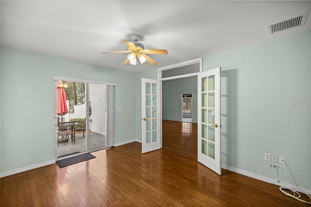 10891 Southwest 69th Circle Ocala, FL 34476 - Photo 17 of 28 a view of a livingroom with wooden floor and a ceiling fan