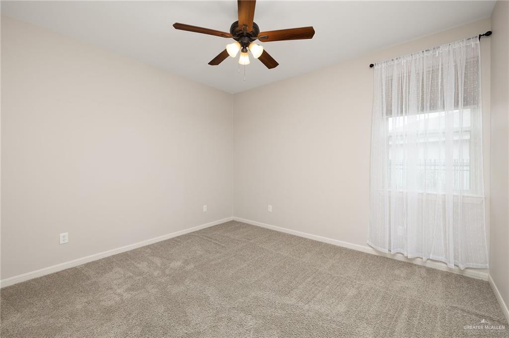 14213 Gorman Fls Road McAllen, TX 78504 - Photo 9 of 13 an empty room with a ceiling fan and a window