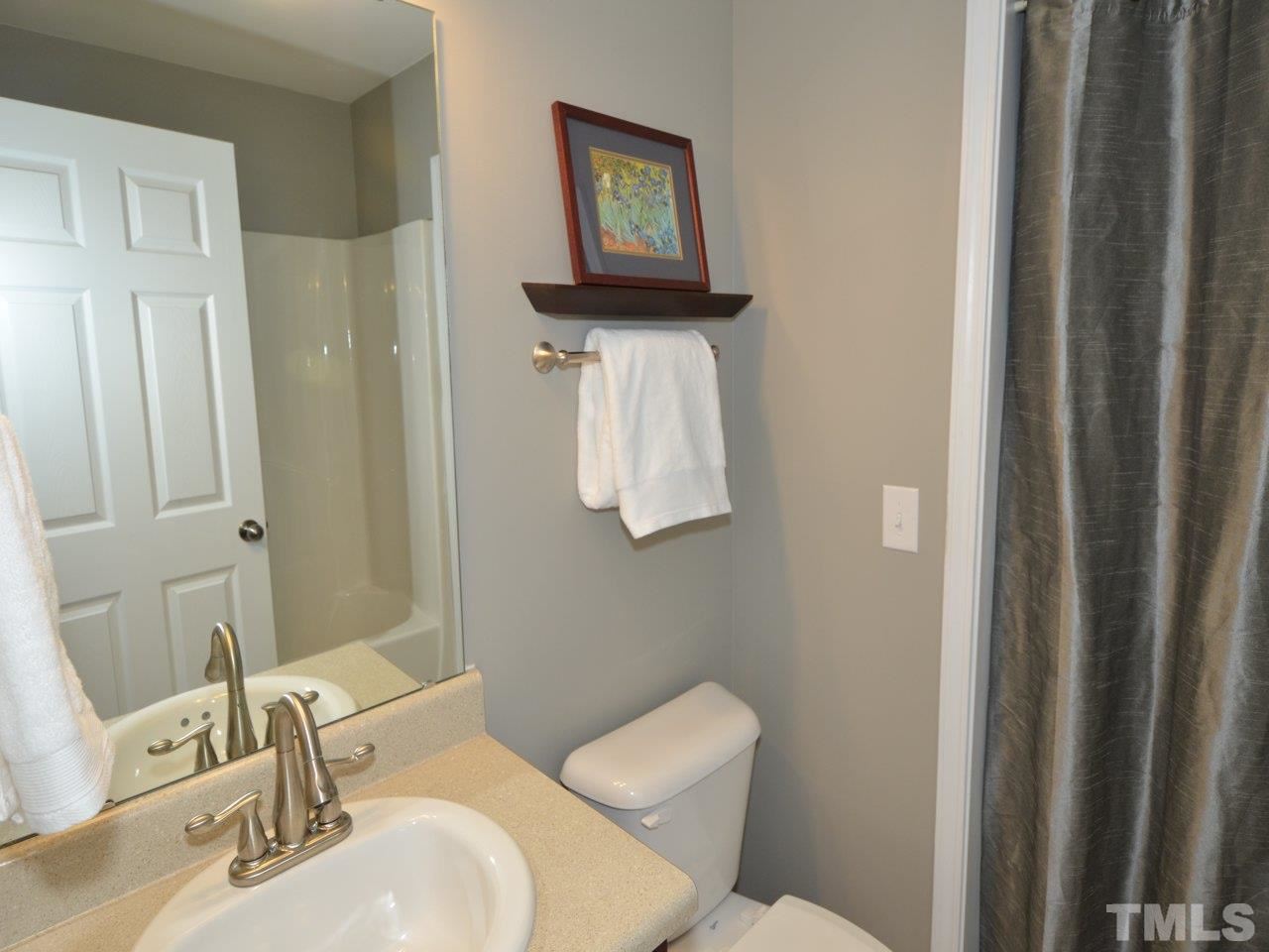 9705 Raya Court Raleigh, NC 27617 - Photo 20 of 25 a bathroom with a toilet a sink and mirror
