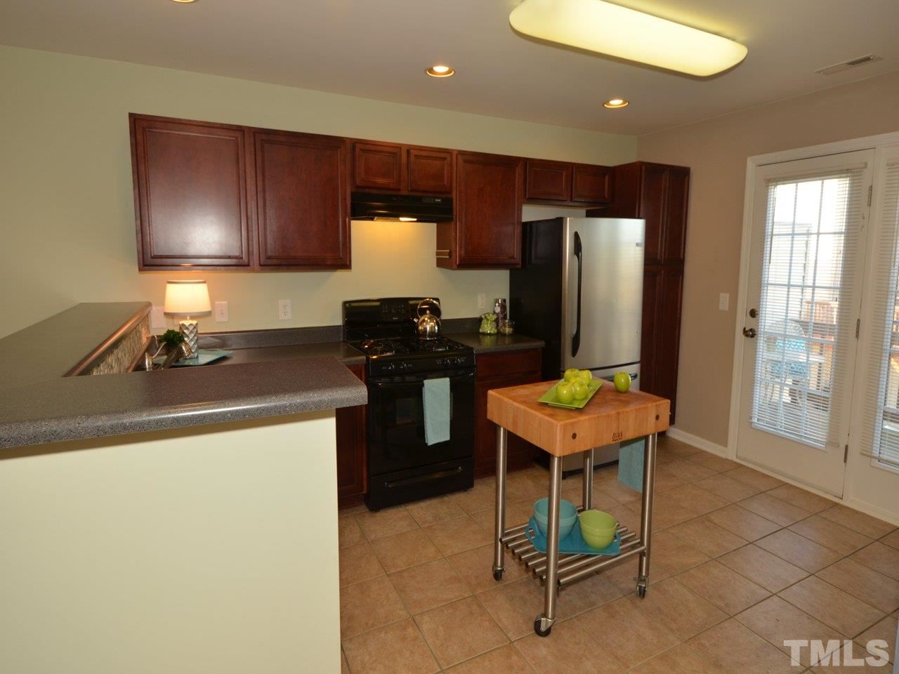 9705 Raya Court Raleigh, NC 27617 - Photo 3 of 25 a kitchen with a sink a counter and a refrigerator