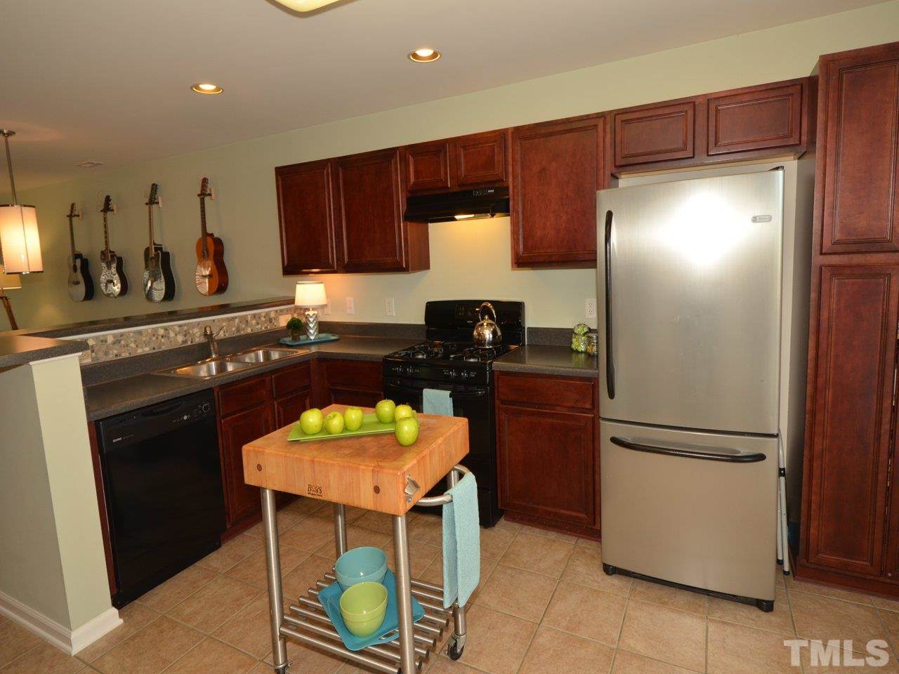 9705 Raya Court Raleigh, NC 27617 - Photo 4 of 25 a kitchen with stainless steel appliances granite countertop a refrigerator a stove a sink and a microwave