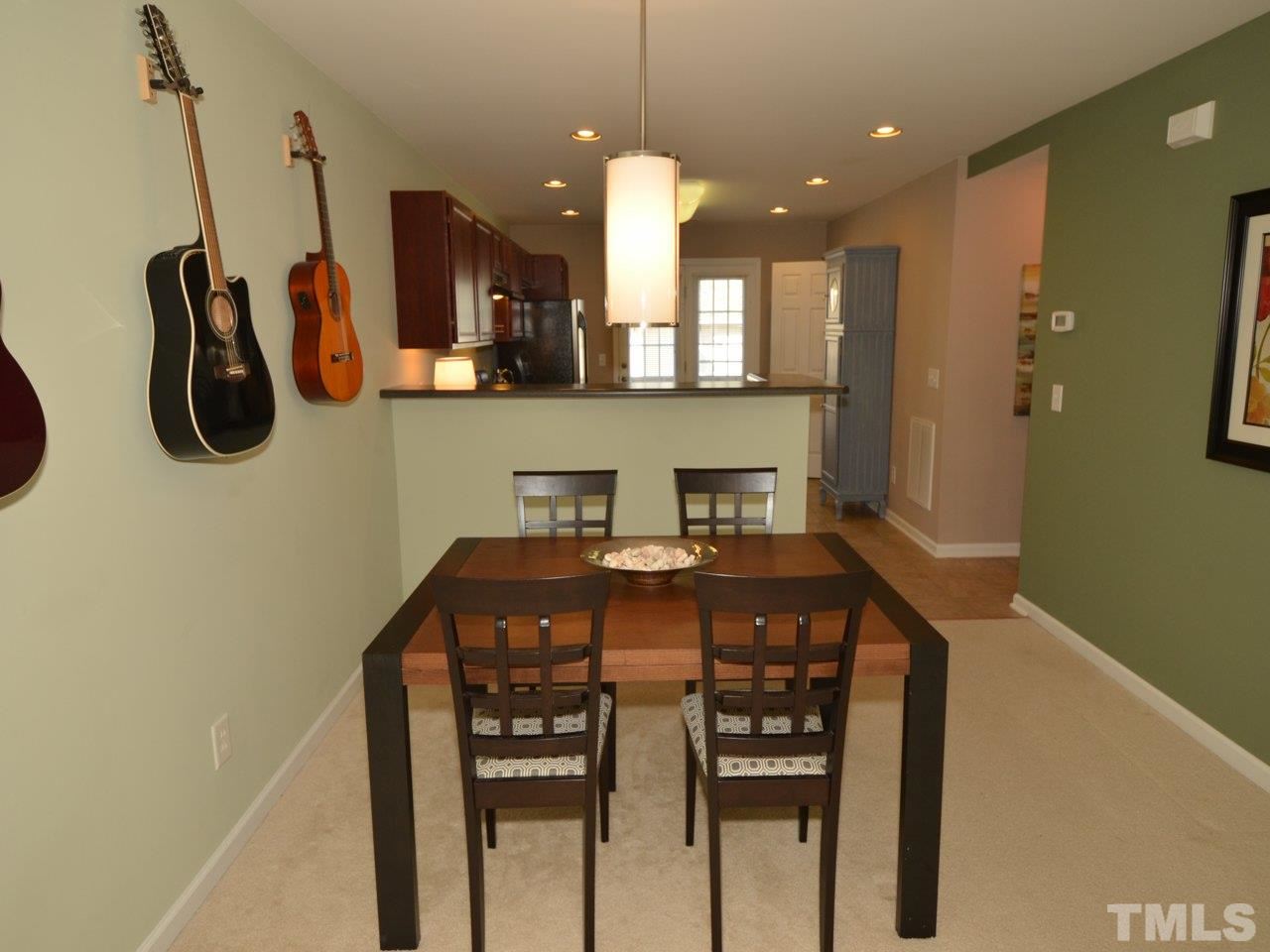 9705 Raya Court Raleigh, NC 27617 - Photo 7 of 25 a kitchen with stainless steel appliances granite countertop a sink a stove and a refrigerator