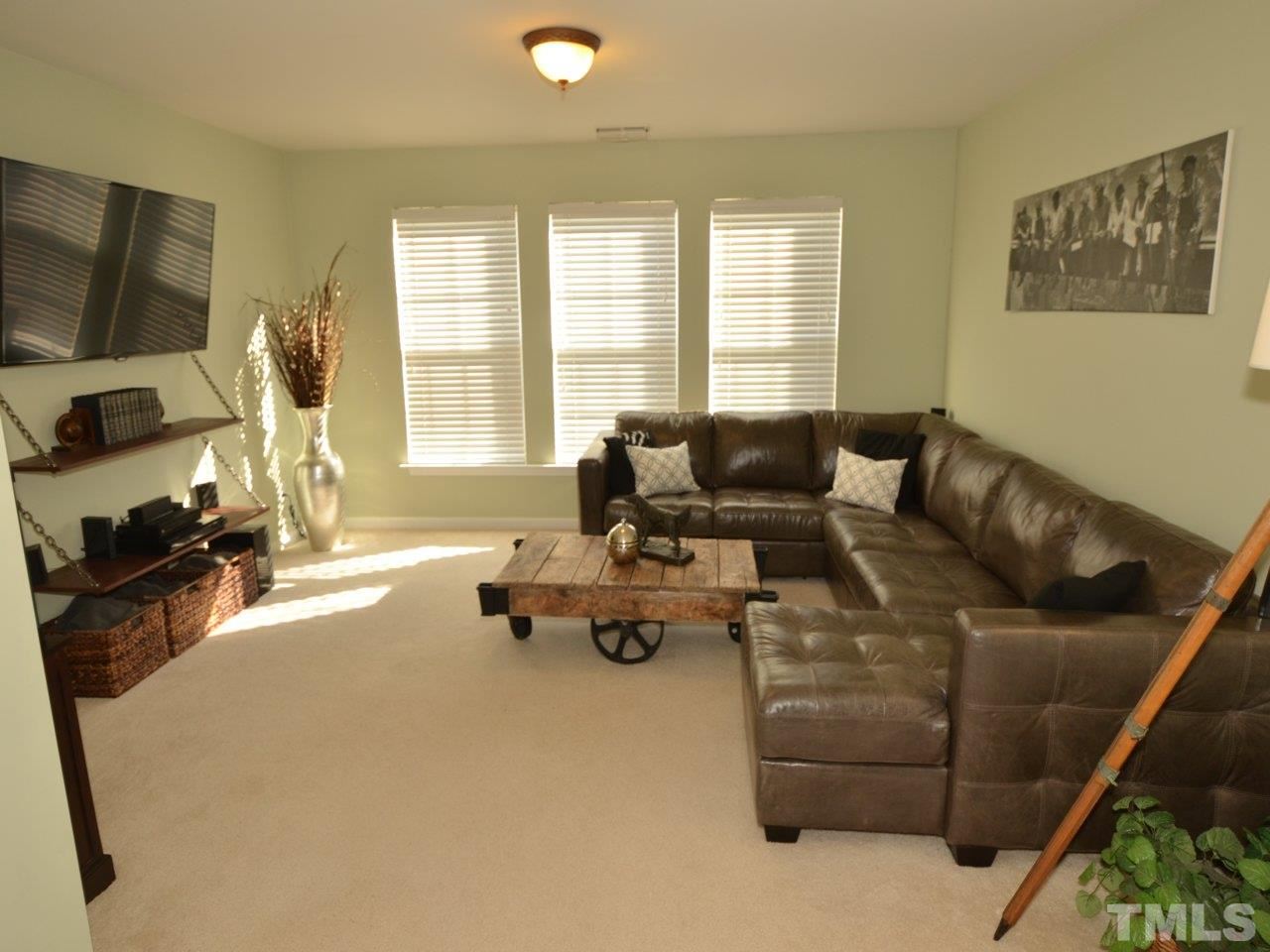 9705 Raya Court Raleigh, NC 27617 - Photo 9 of 25 a living room with furniture a flat screen tv and a large window