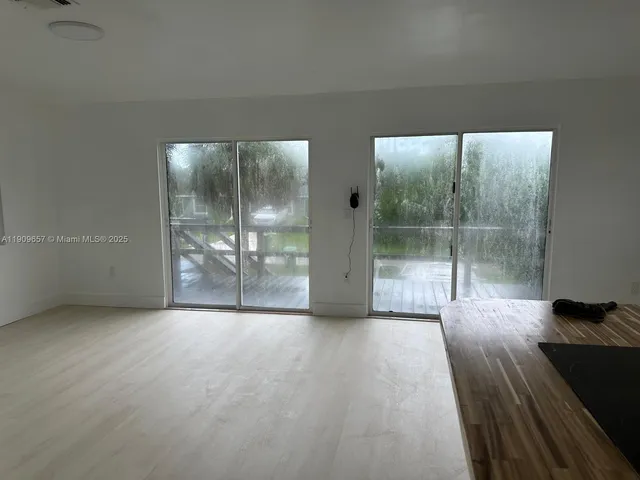 a view of a big room with windows and wooden floor