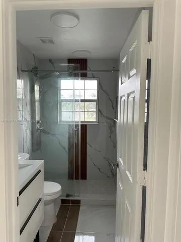 a bathroom with a toilet a sink and shower