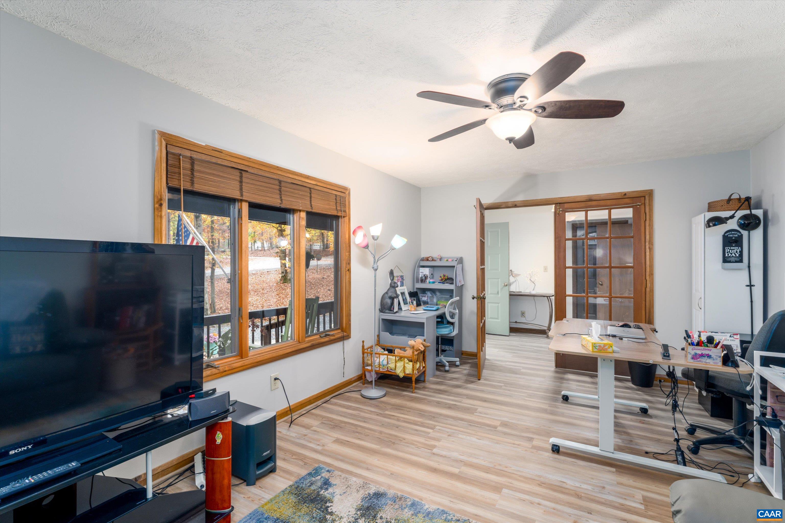 41 Dogleg Road Palmyra, VA 22963 - Photo 12 of 47 a living room with furniture a flat screen tv and a floor to ceiling window