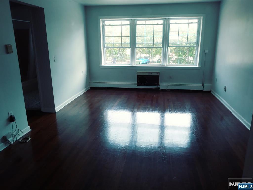 565 Grove, Unit B12 Clifton, NJ 07013 - Photo 13 of 19 an empty room with wooden floor and windows