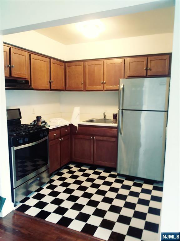 565 Grove, Unit B12 Clifton, NJ 07013 - Photo 14 of 19 a kitchen with a refrigerator and cabinets