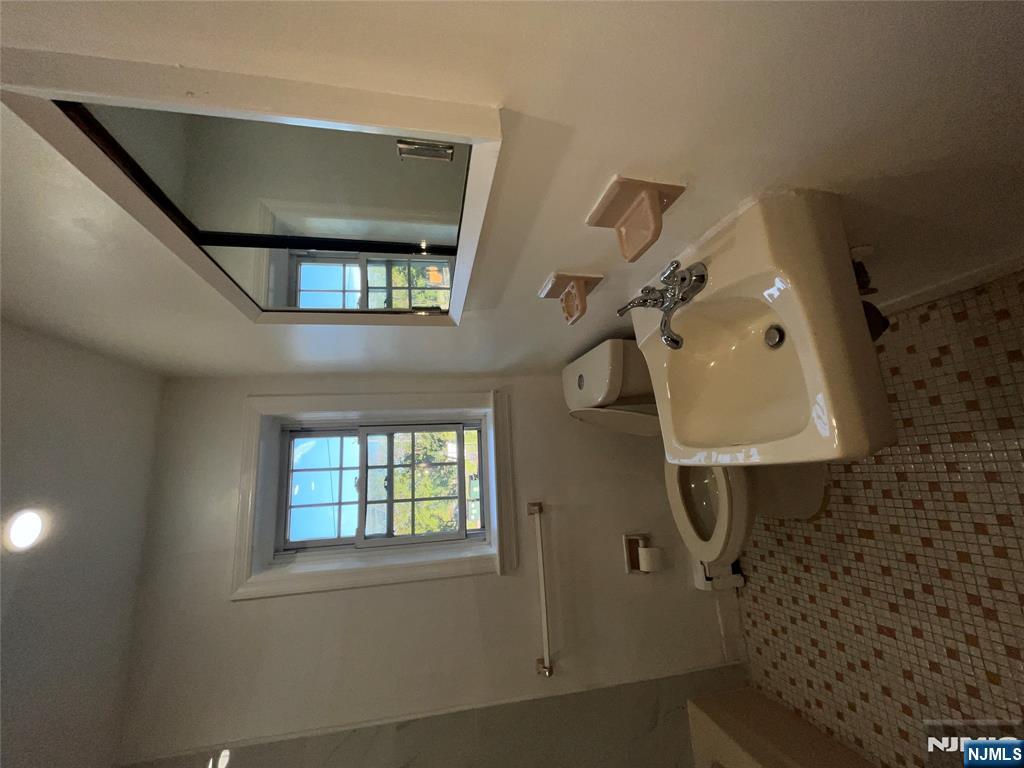 565 Grove, Unit B12 Clifton, NJ 07013 - Photo 18 of 19 a bathroom with a sink toilet and a mirror