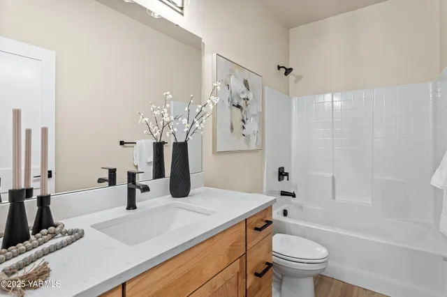 a bathroom with a granite countertop sink a toilet and shower
