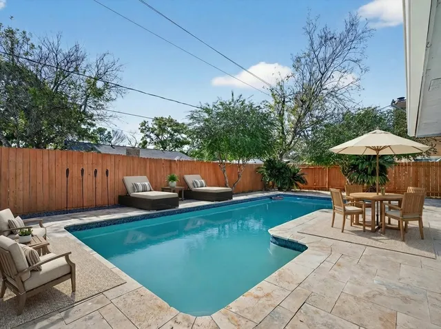 a house view with swimming pool in front of it