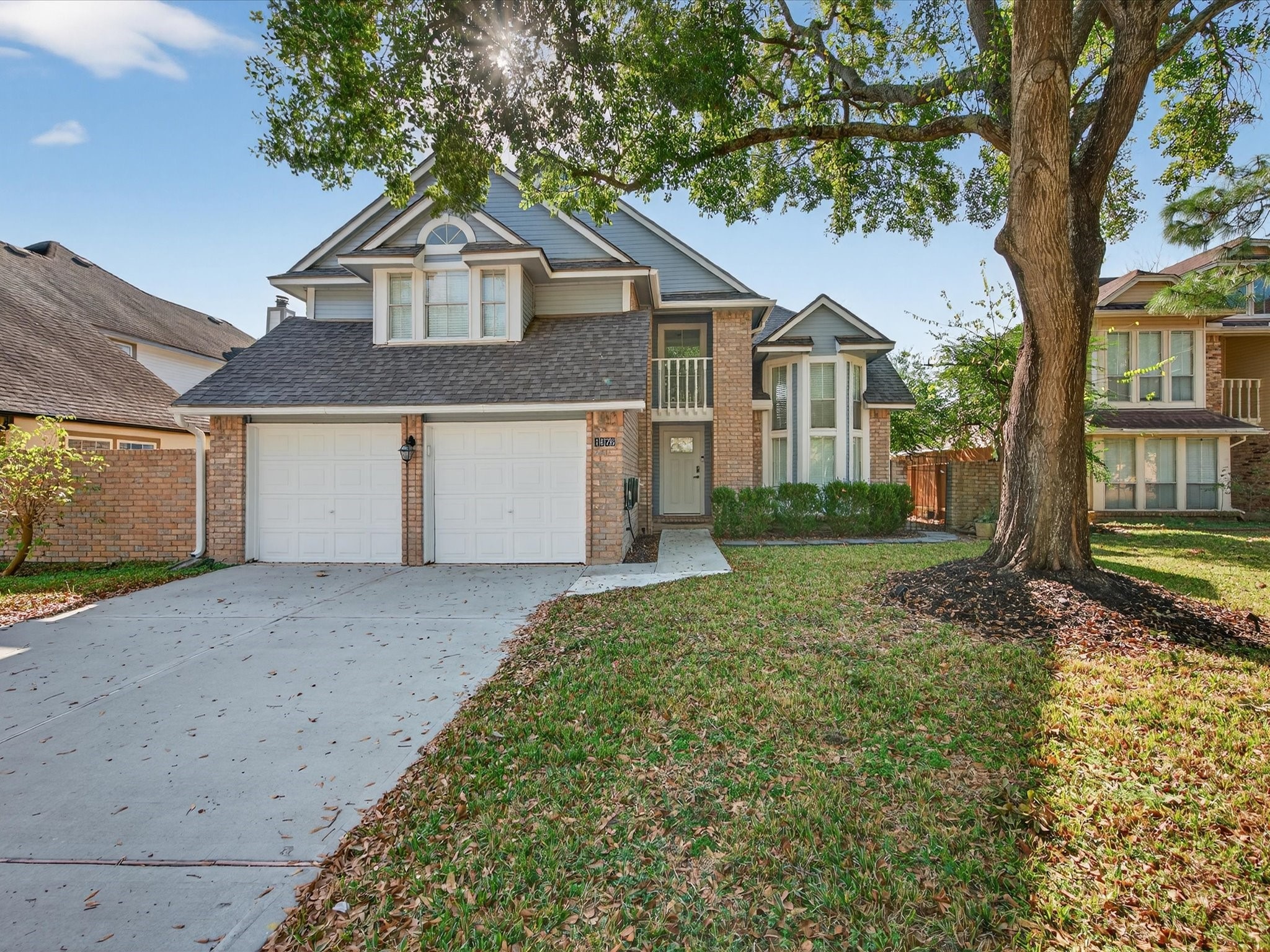 1676 Beaconshire Houston, TX 77077 - Photo 2 of 28 a front view of a house with a yard and garage