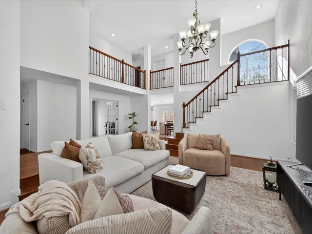 a living room with furniture and a chandelier