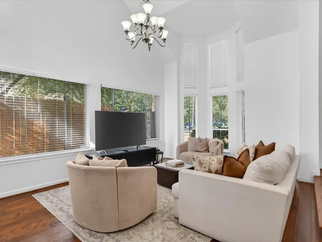 a living room with furniture potted plant and a large window