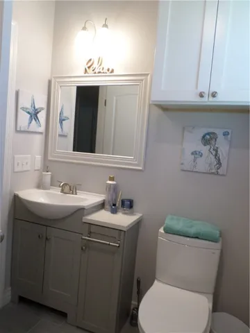 a bathroom with a toilet sink and mirror