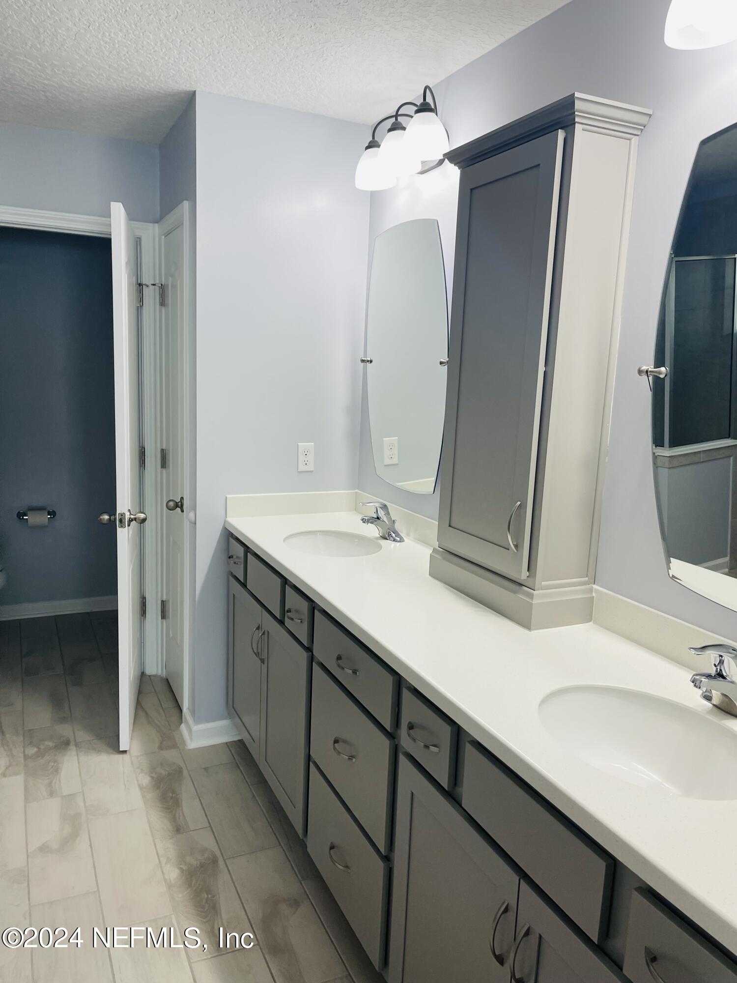 86508 Secluded Place Yulee, FL 32097 - Photo 21 of 43 a bathroom with a double vanity sink a mirror and a shower