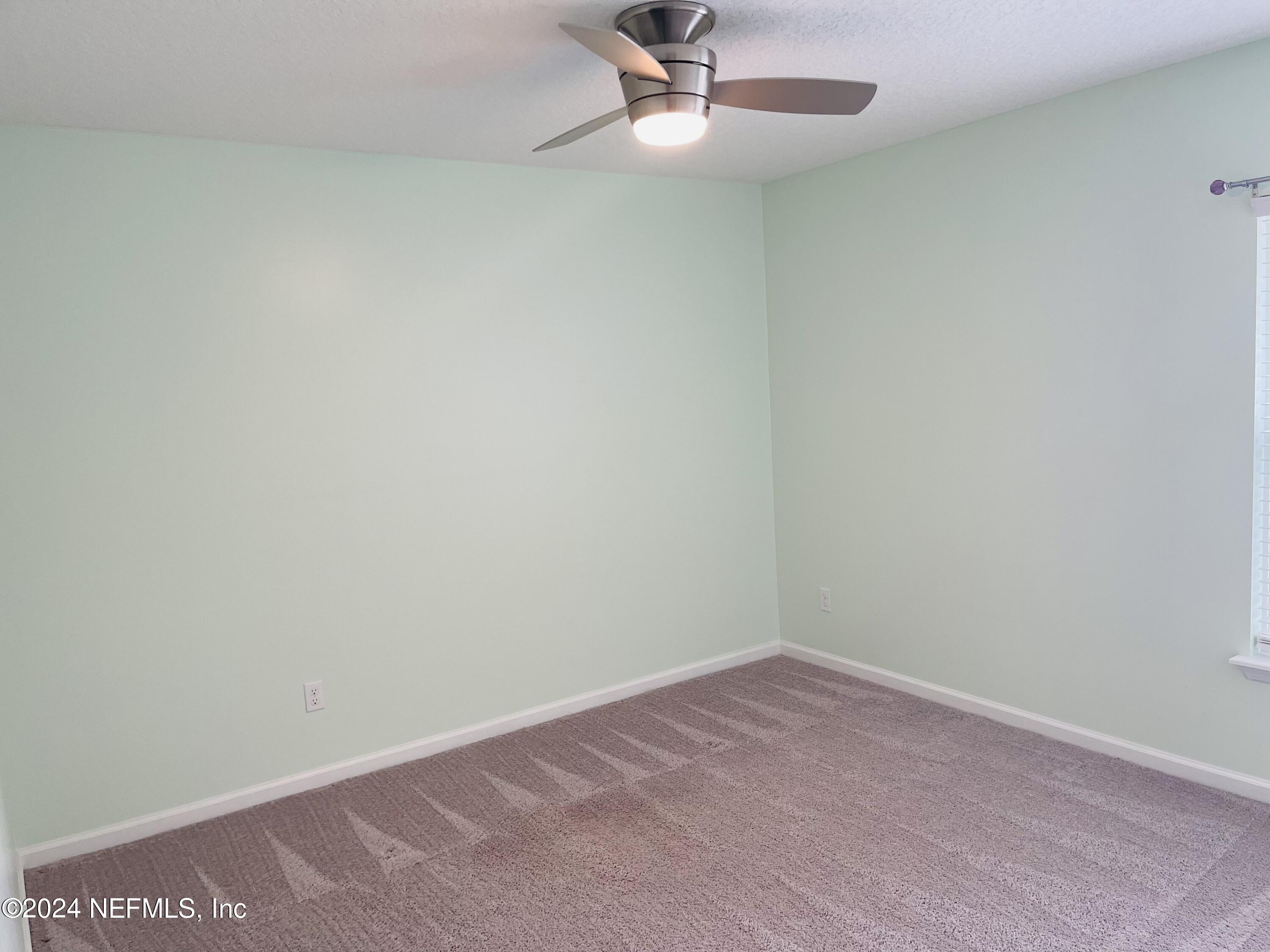 86508 Secluded Place Yulee, FL 32097 - Photo 28 of 43 an empty room with a ceiling fan and carpet