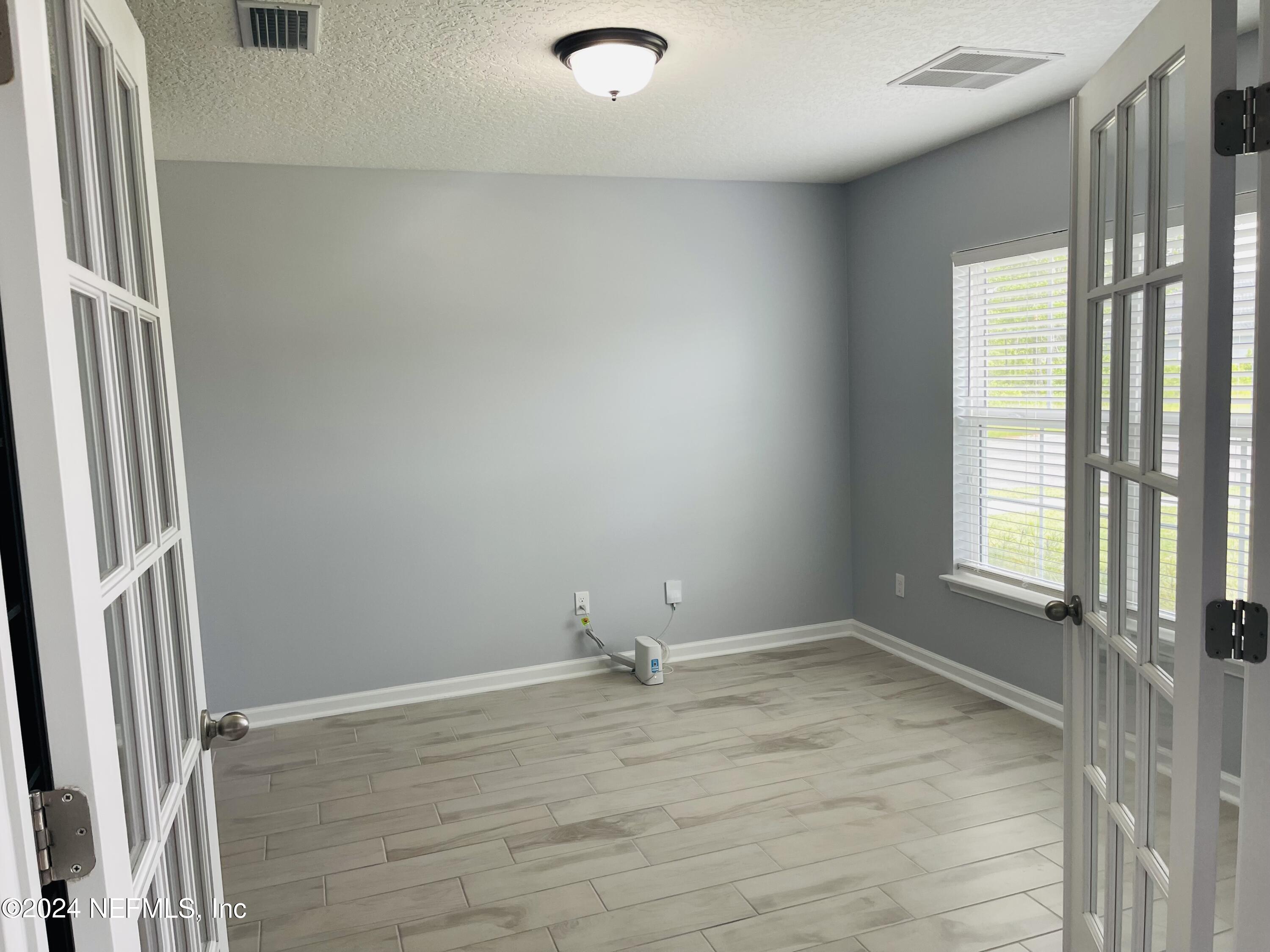 86508 Secluded Place Yulee, FL 32097 - Photo 4 of 43 an empty room with wooden floor and windows