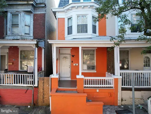 front view of a brick house with a small yard