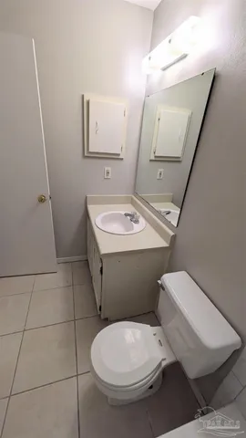 a white toilet sitting next to a bathroom sink and a mirror