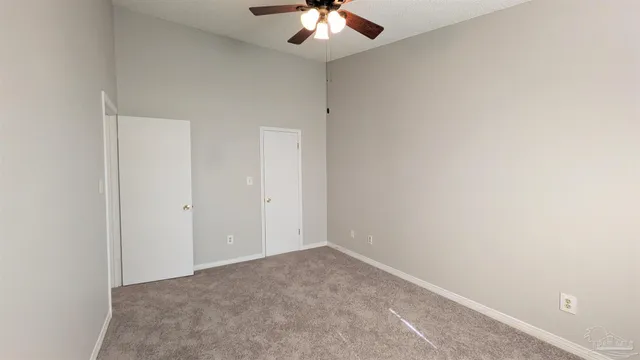 an empty room with a chandelier fan