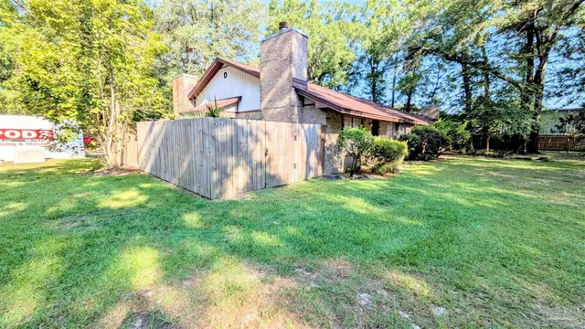 a view of a house with a yard and sitting area