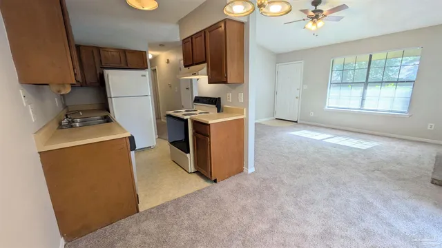 a kitchen with stainless steel appliances granite countertop a stove top oven a sink a refrigerator and a stove