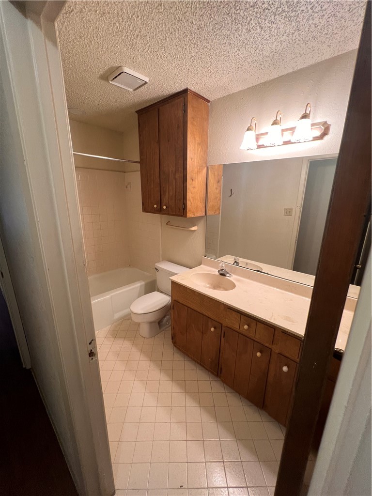4021 Acushnet Drive, Unit F Corpus Christi, TX 78413 - Photo 11 of 21 a bathroom with a sink a toilet and mirror