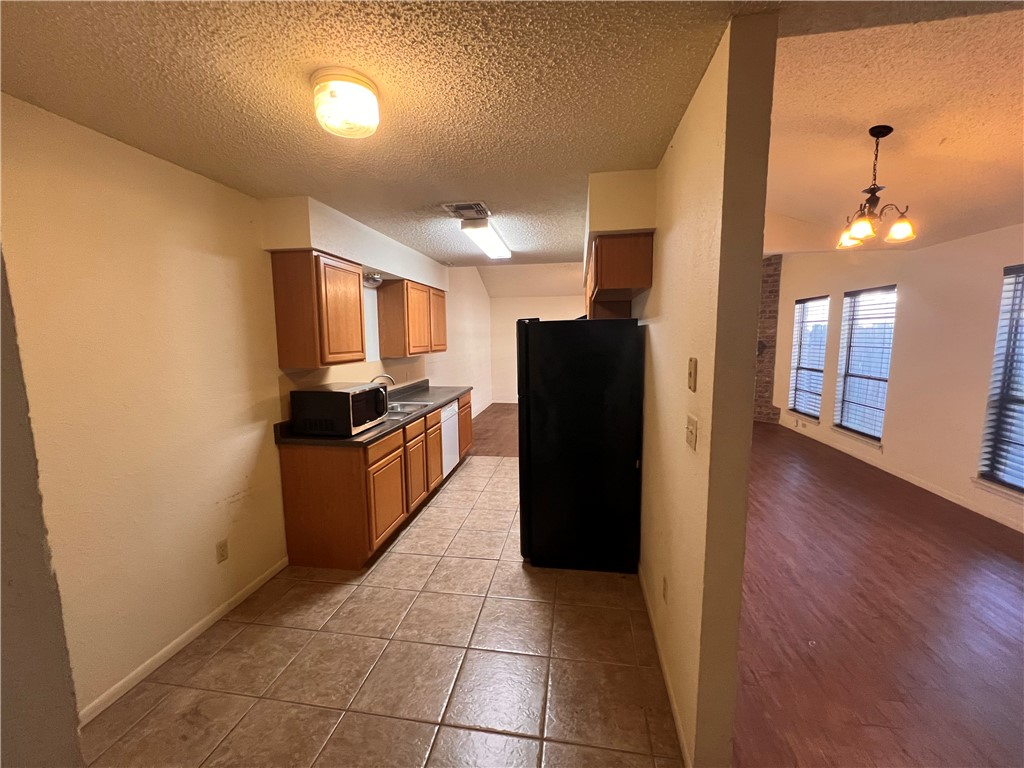 4021 Acushnet Drive, Unit F Corpus Christi, TX 78413 - Photo 20 of 21 a kitchen with granite countertop a refrigerator and a stove top oven
