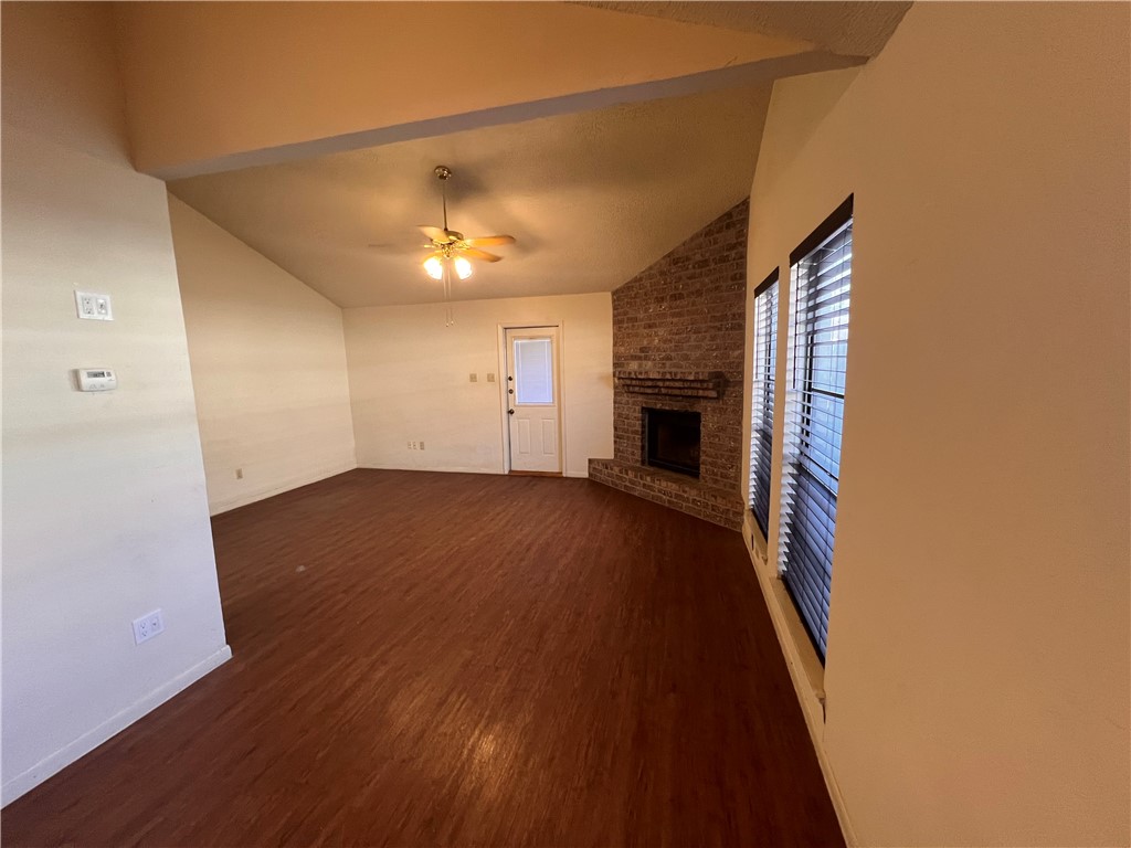 4021 Acushnet Drive, Unit F Corpus Christi, TX 78413 - Photo 5 of 21 an empty room with wooden floor fireplace and windows