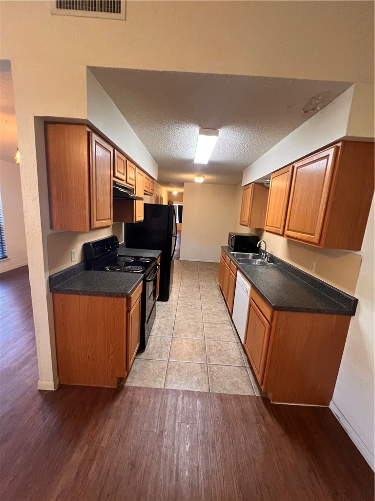 4021 Acushnet Drive, Unit F Corpus Christi, TX 78413 - Photo 6 of 21 a kitchen with stainless steel appliances granite countertop a stove a sink and a refrigerator