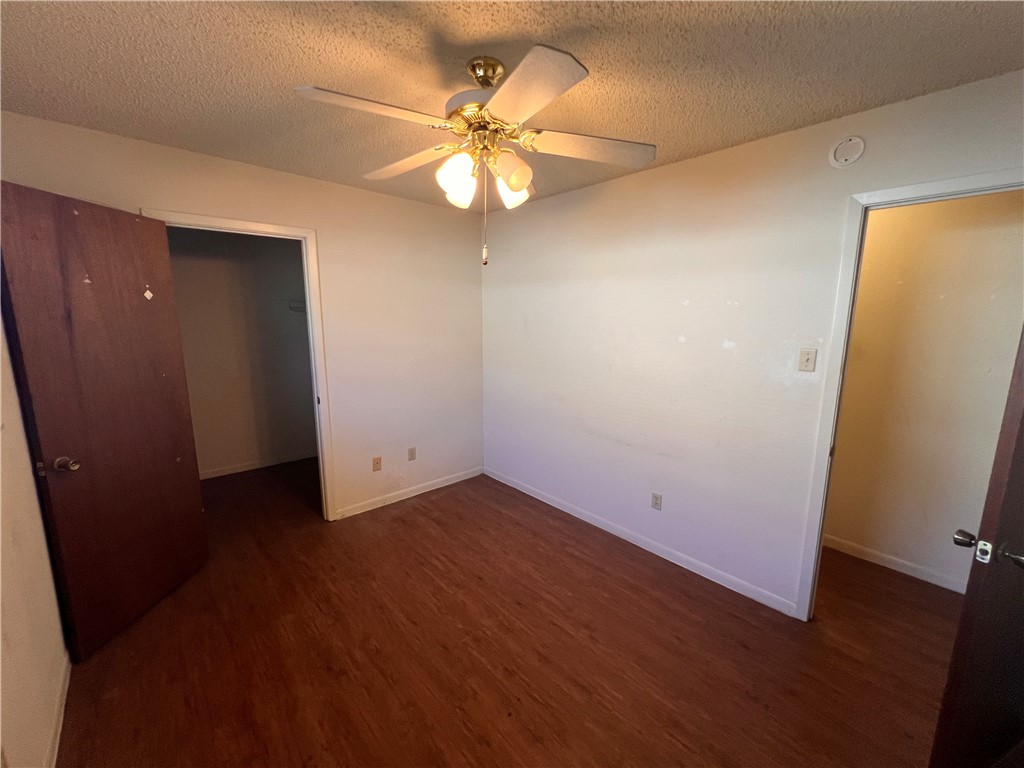 4021 Acushnet Drive, Unit F Corpus Christi, TX 78413 - Photo 7 of 21 an empty room with wooden floor and fan