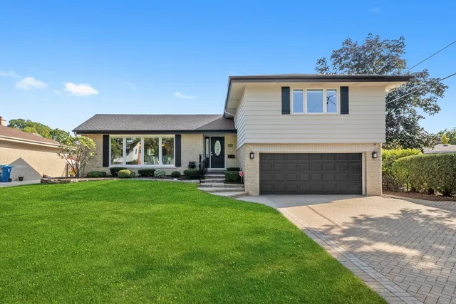 a front view of a house with a garden and yard