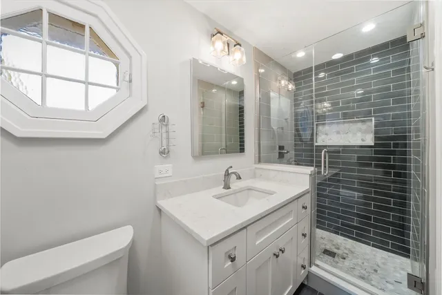 a bathroom with a sink a toilet and a large mirror