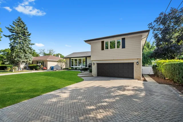 a front view of a house with a garden and yard