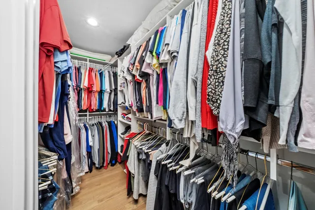 a view of walk in closet with clothes