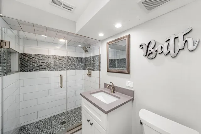 a bathroom with a sink a toilet and mirror