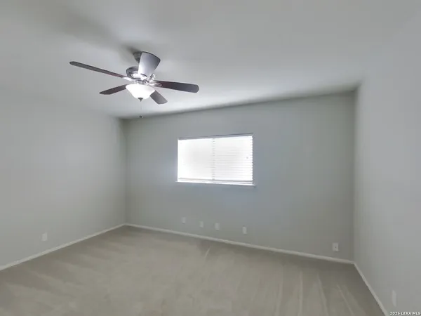 an empty room with a window and a fan