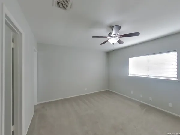 an empty room with a window and a ceiling fan