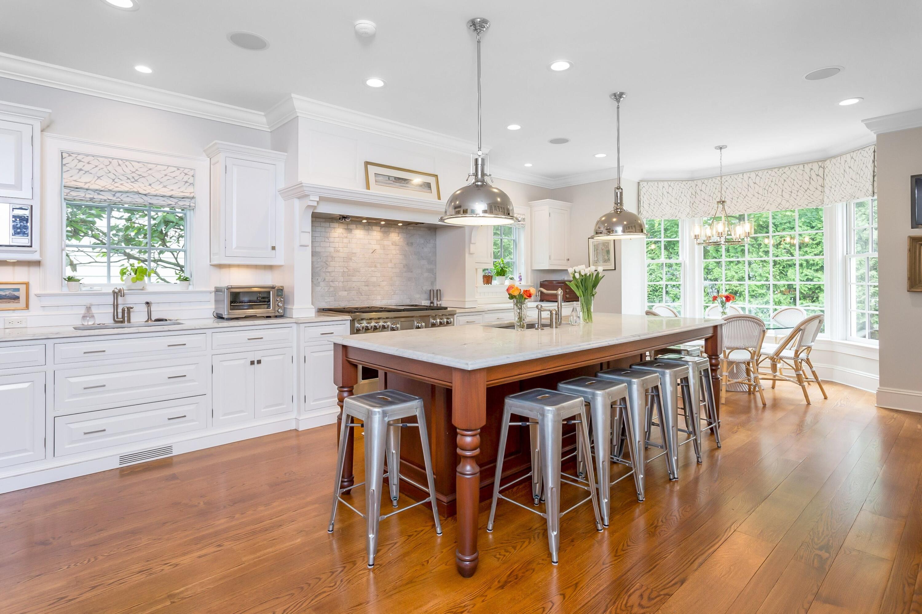 2 Harbor Bluff Lane Rowayton, CT 06853 - Photo 8 of 37 a kitchen with kitchen island granite countertop a table chairs sink and cabinets